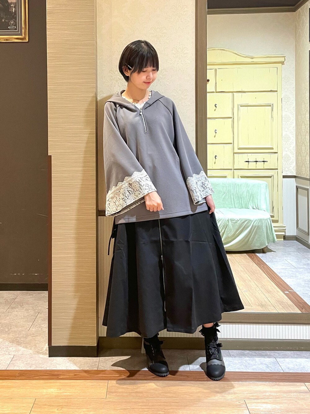 ブラック系のブーツ、ブラック系のトートバッグ、ホワイト系のタンクトップを着用したレディースの夏コーディネートの6枚目の写真