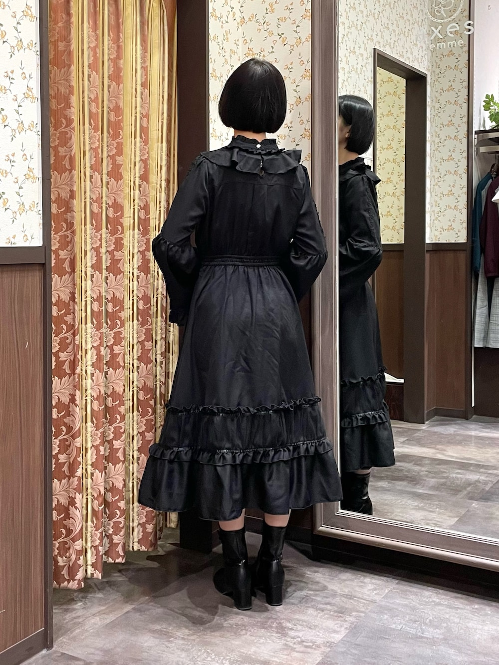 ブラック系のワンピース、ブラック系のブーツ、レッド系のショルダーバッグを着用したレディースの冬コーディネートの6枚目の写真