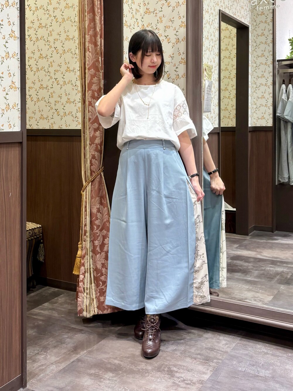 グリーン系のシャツ/ブラウス、ベージュ系のショルダーバッグ、ブラウン系のブーツを着用したレディースの夏コーディネートの3枚目の写真