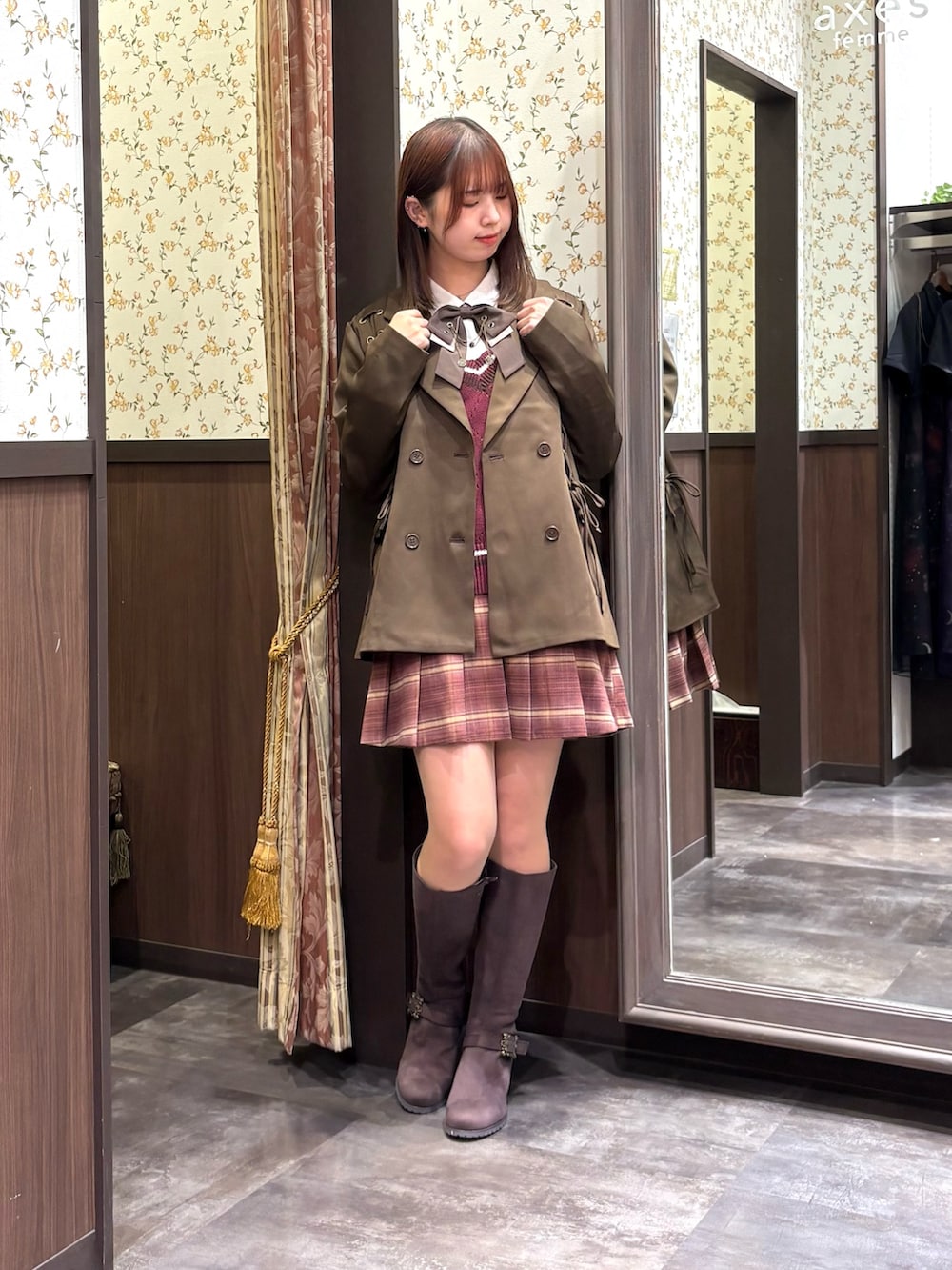 レッド系のベスト、ピンク系のその他パンツ、ブラウン系のブーツを着用したレディースの秋コーディネートの2枚目の写真