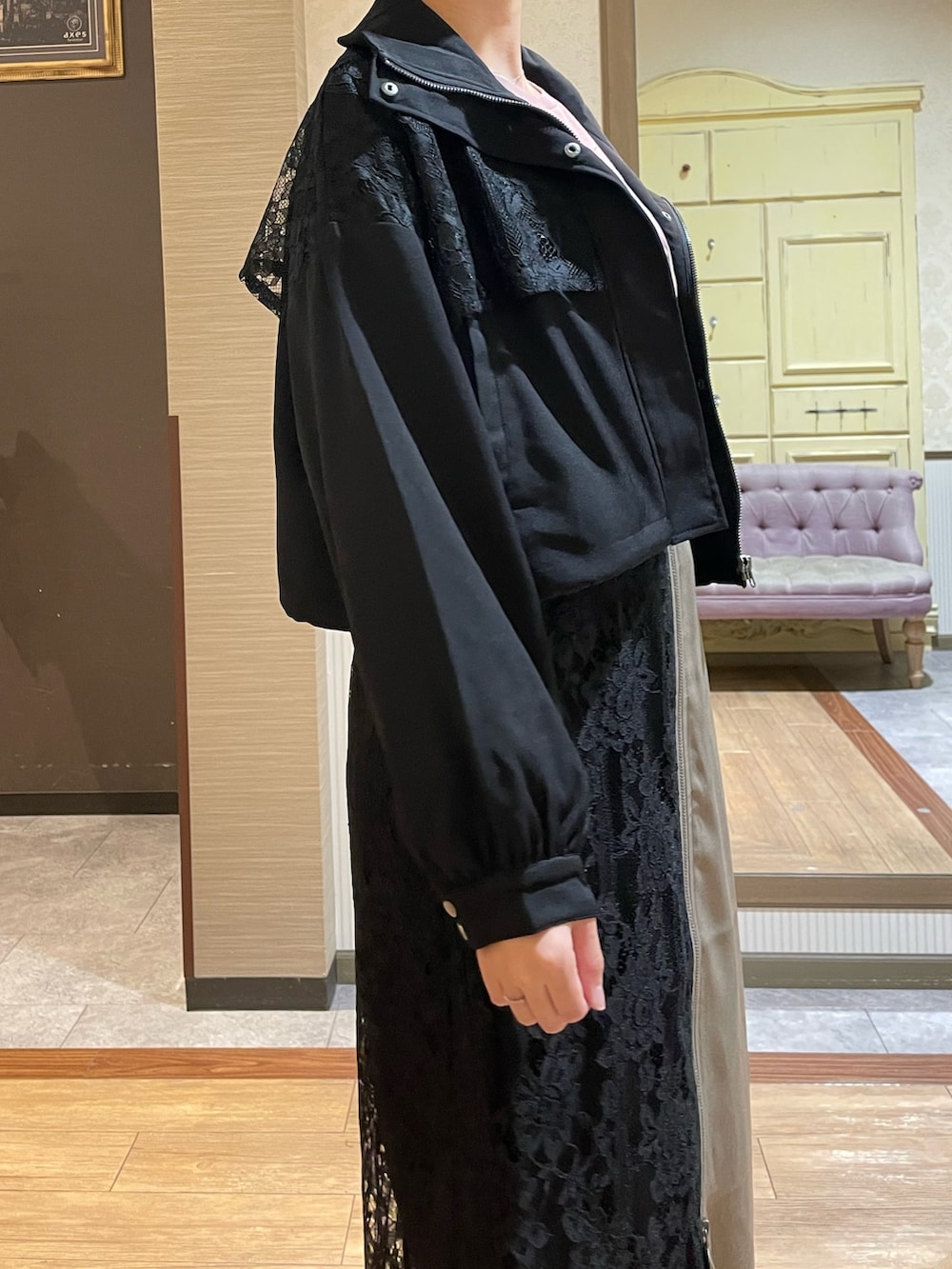 ベージュ系のスカート、ブラウン系のTシャツ/カットソー、ブラック系のブルゾンを着用したレディースの秋コーディネートの6枚目の写真