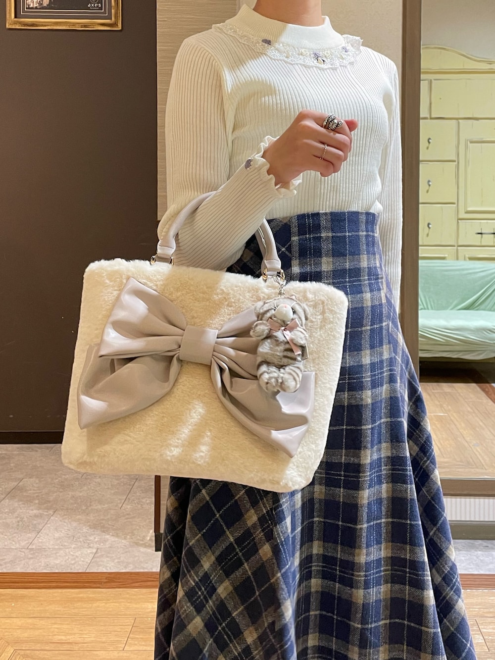 ホワイト系のその他アウター、ホワイト系のニット/セーター、ブルー系のスカートを着用したレディースの秋コーディネートの6枚目の写真