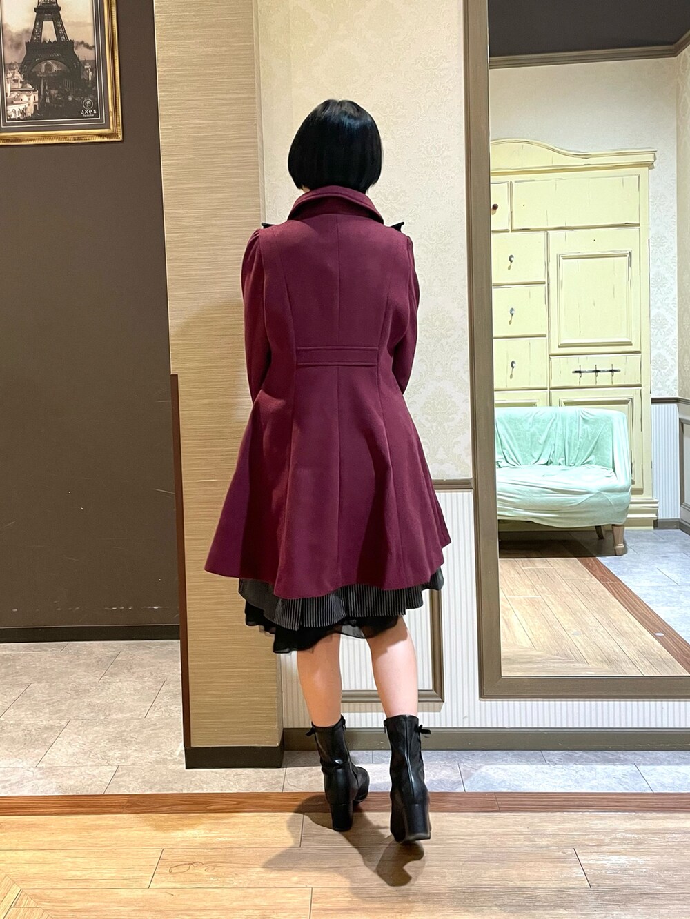 レッド系のステンカラーコート、ブラック系のシャツ/ブラウス、ブラック系のブーツを着用したレディースの秋コーディネートの7枚目の写真