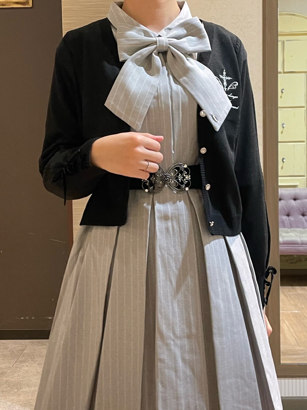 グレー系のワンピース、ブラック系のショルダーバッグ、ブラック系のブーツを着用したレディースの秋コーディネートの3枚目の写真