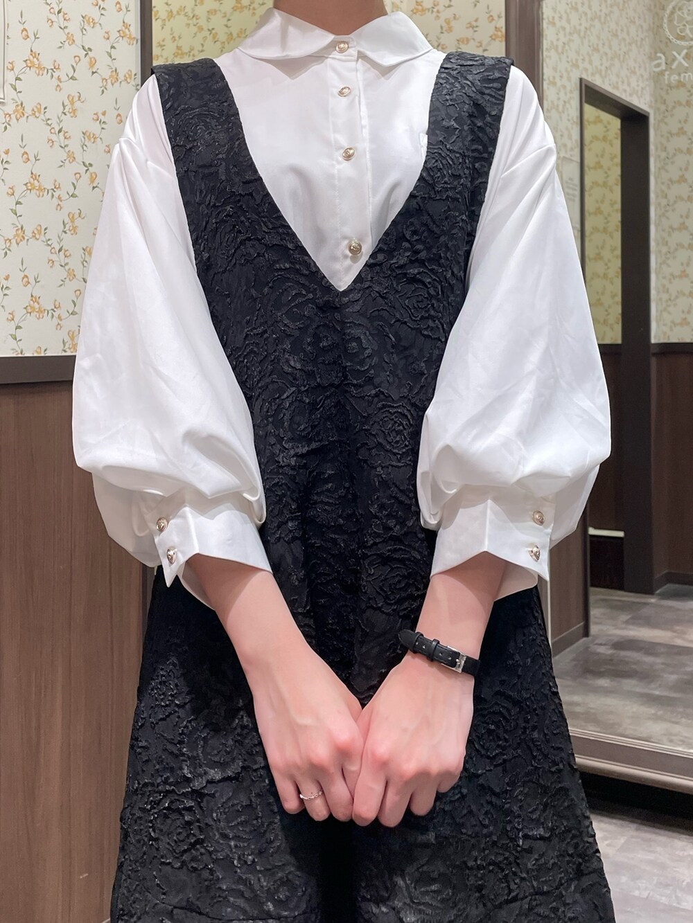 ホワイト系のシャツ/ブラウス、ブラック系のジャンパースカート、ブラック系のブーツを着用したレディースの春コーディネートの7枚目の写真