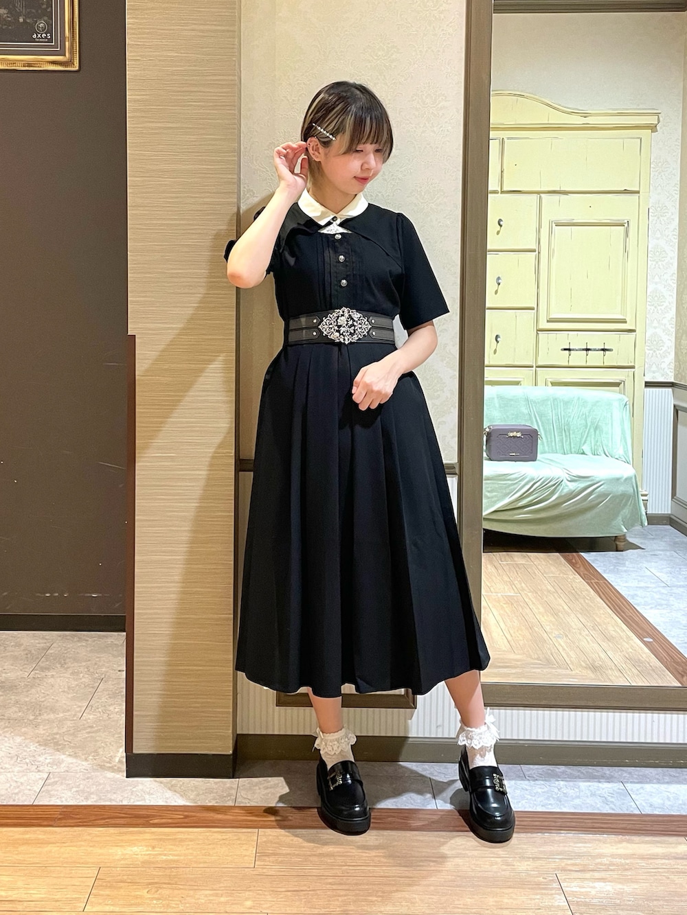 パープル系のショルダーバッグ、ブラック系のワンピース、ホワイト系のタンクトップを着用したレディースの夏コーディネートの5枚目の写真