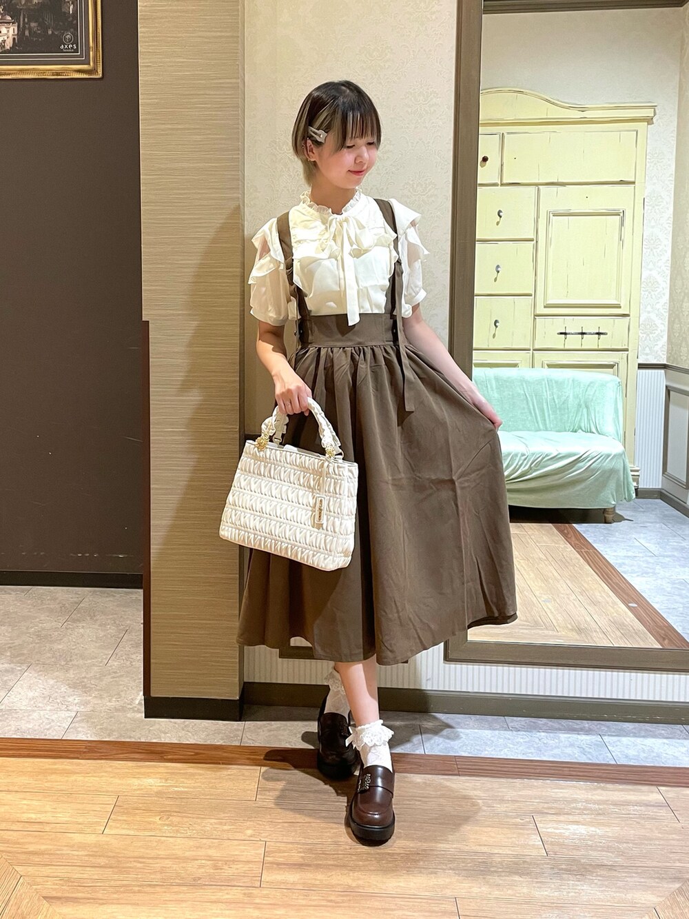 ブラウン系のパンプス、ホワイト系のショルダーバッグ、ブラウン系のスカートを着用したレディースの夏コーディネートの3枚目の写真