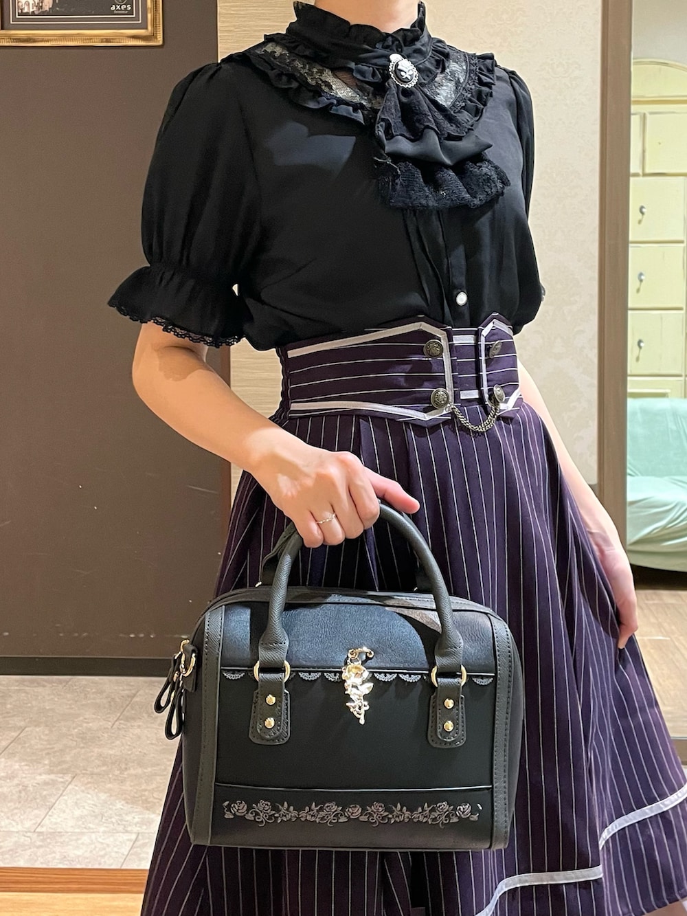 ホワイト系のタンクトップ、ブラック系のパンプス、ブラック系のボストンバッグを着用したレディースの夏コーディネートの7枚目の写真