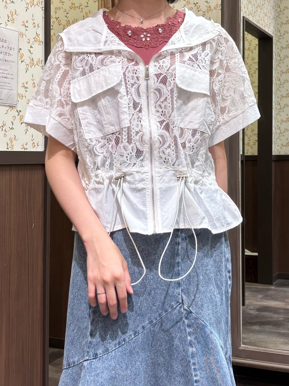 ホワイト系のカーディガン/ボレロ、レッド系のタンクトップ、ブルー系のデニムスカートを着用したレディースの春コーディネートの6枚目の写真