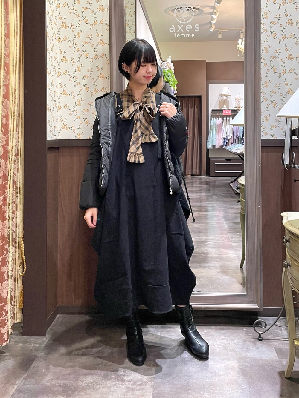 ブラック系のブーツ、ブラック系のジャンパースカート、ブラウン系のシャツ/ブラウスを着用したレディースの秋コーディネートの2枚目の写真