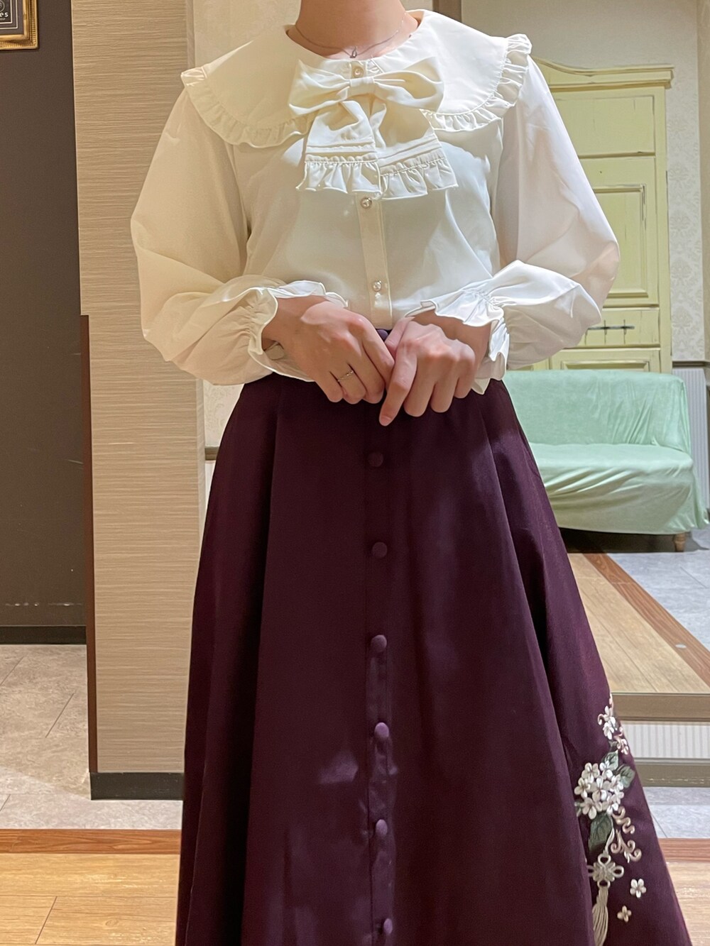 レッド系のスカート、ブラック系のブーツ、ブラック系のショルダーバッグを着用したレディースの秋コーディネートの7枚目の写真