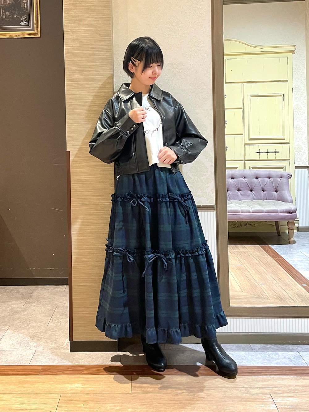 ブラック系のショルダーバッグ、ブラック系のブーツ、グリーン系のスカートを着用したレディースの秋コーディネートの4枚目の写真