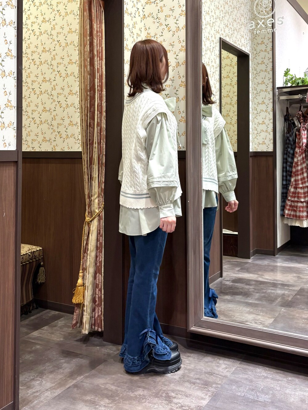 グリーン系のシャツ/ブラウス、ホワイト系のベスト、グリーン系のボストンバッグを着用したレディースの冬コーディネートの5枚目の写真