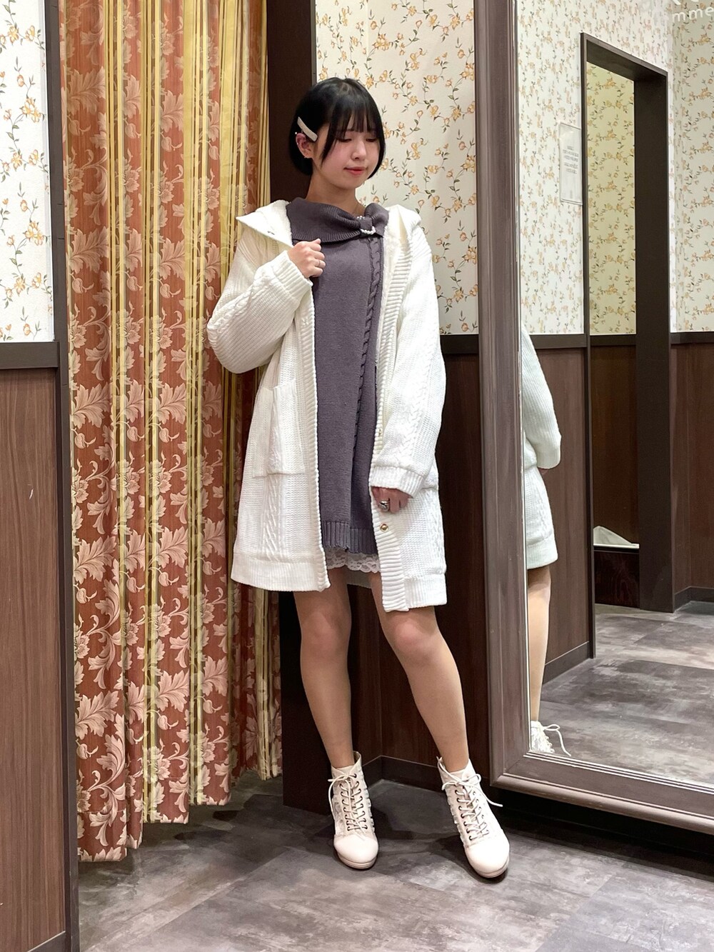 ホワイト系のその他アウター、グレー系のチュニック、ホワイト系のブーツを着用したレディースの冬コーディネートの2枚目の写真