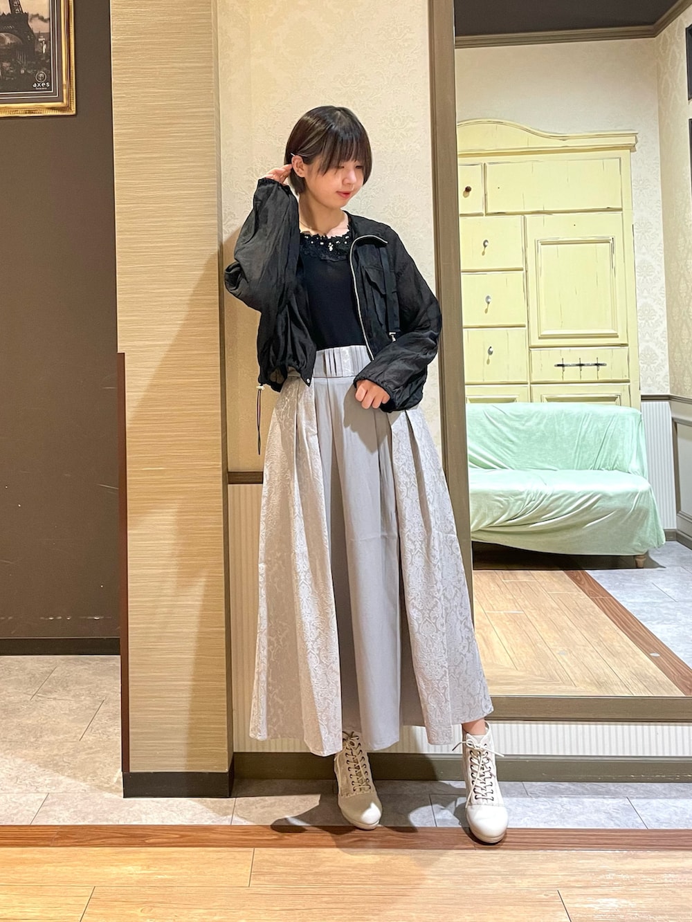 ブラック系のタンクトップ、ブラック系のブルゾン、ホワイト系のショルダーバッグを着用したレディースの秋コーディネートの3枚目の写真