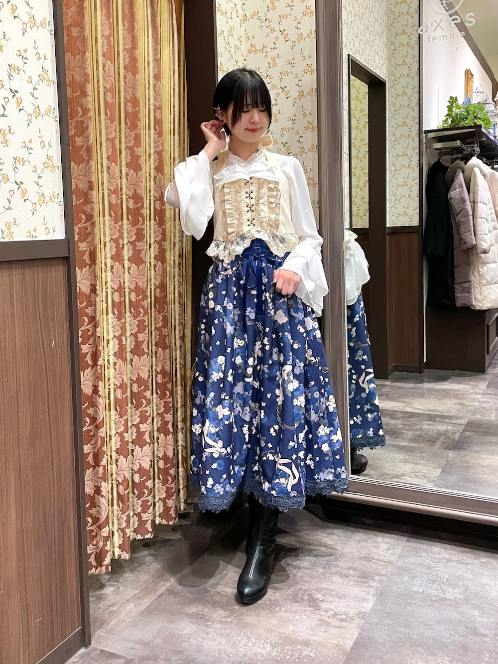 ホワイト系のシャツ/ブラウス、ホワイト系のショルダーバッグ、ブラック系のブーツを着用したレディースの冬コーディネートの2枚目の写真