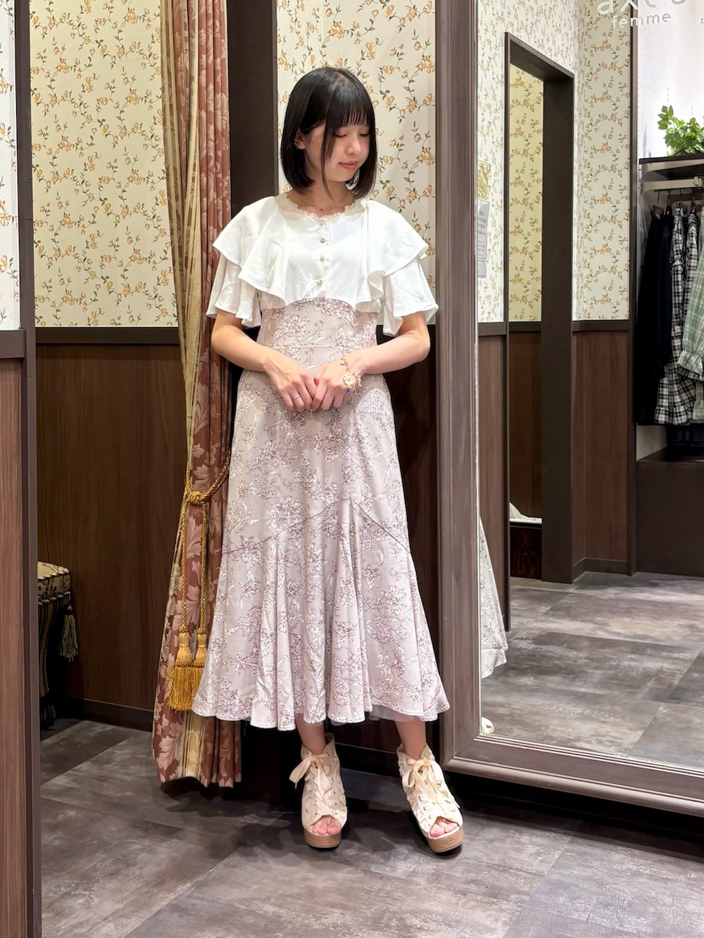ベージュ系のワンピース、ホワイト系のタンクトップ、ベージュ系のショルダーバッグを着用したレディースの夏コーディネートの3枚目の写真