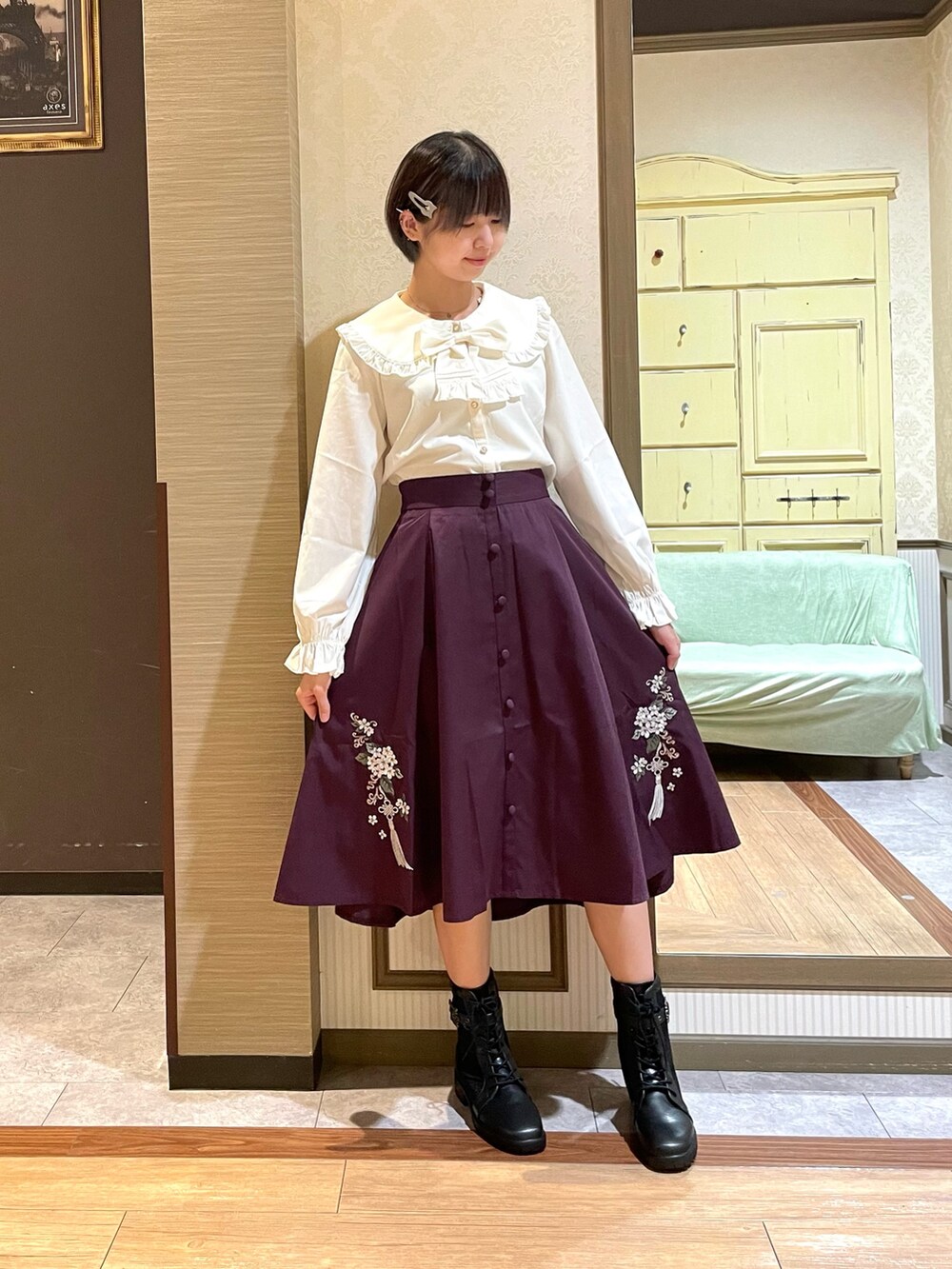 レッド系のスカート、ブラック系のブーツ、ブラック系のショルダーバッグを着用したレディースの秋コーディネートの5枚目の写真