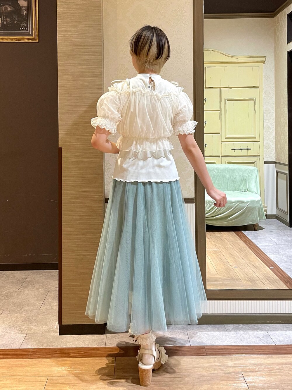 ホワイト系のタンクトップ、ホワイト系のサンダル、グリーン系のスカートを着用したレディースの夏コーディネートの7枚目の写真