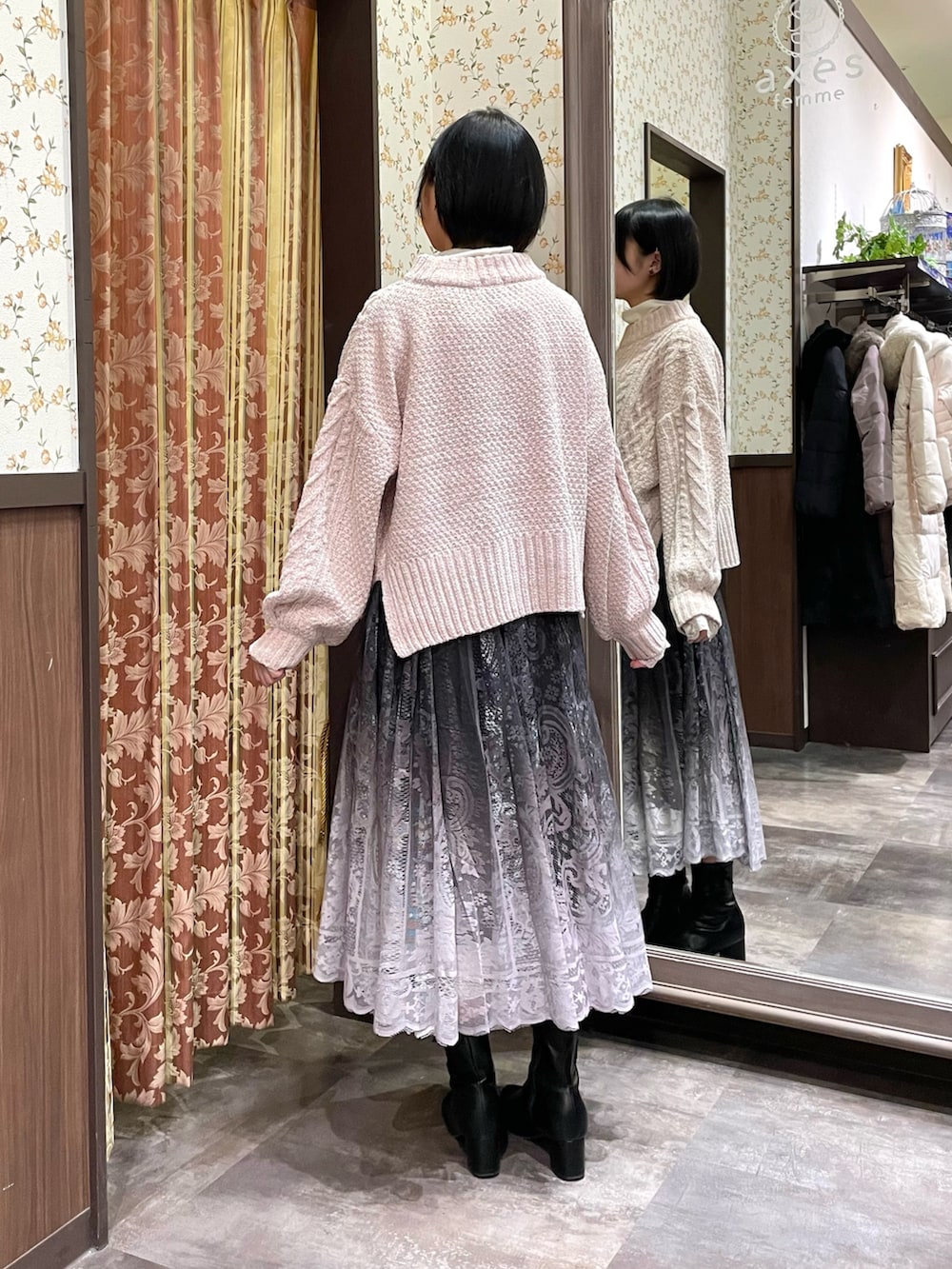 ホワイト系のダッフルコート、ピンク系のニット/セーター、ブラウン系のスカートを着用したレディースの冬コーディネートの6枚目の写真