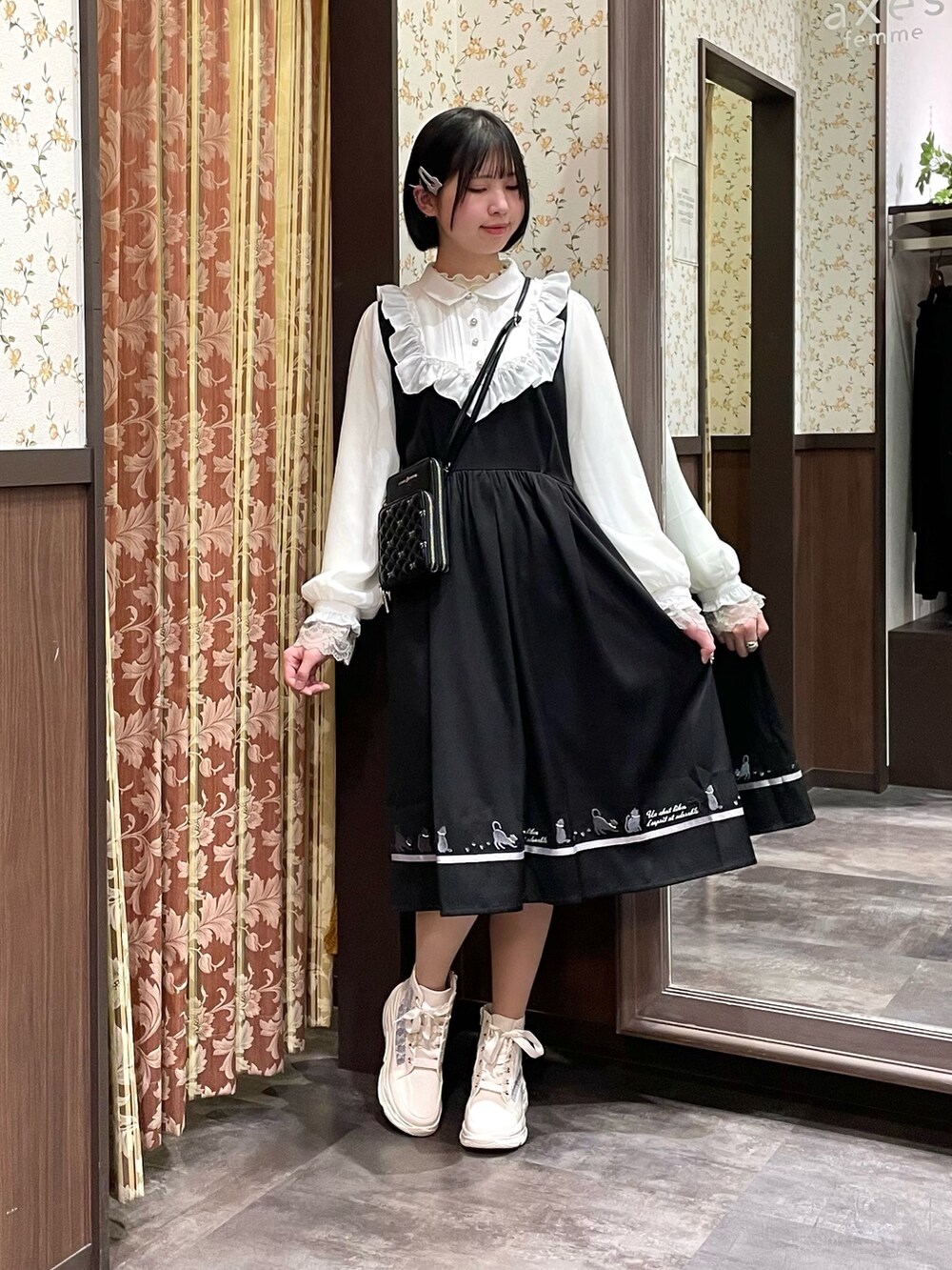 ホワイト系のスニーカー、ブラック系のワンピース、ブラック系のショルダーバッグを着用したレディースの春コーディネートの4枚目の写真