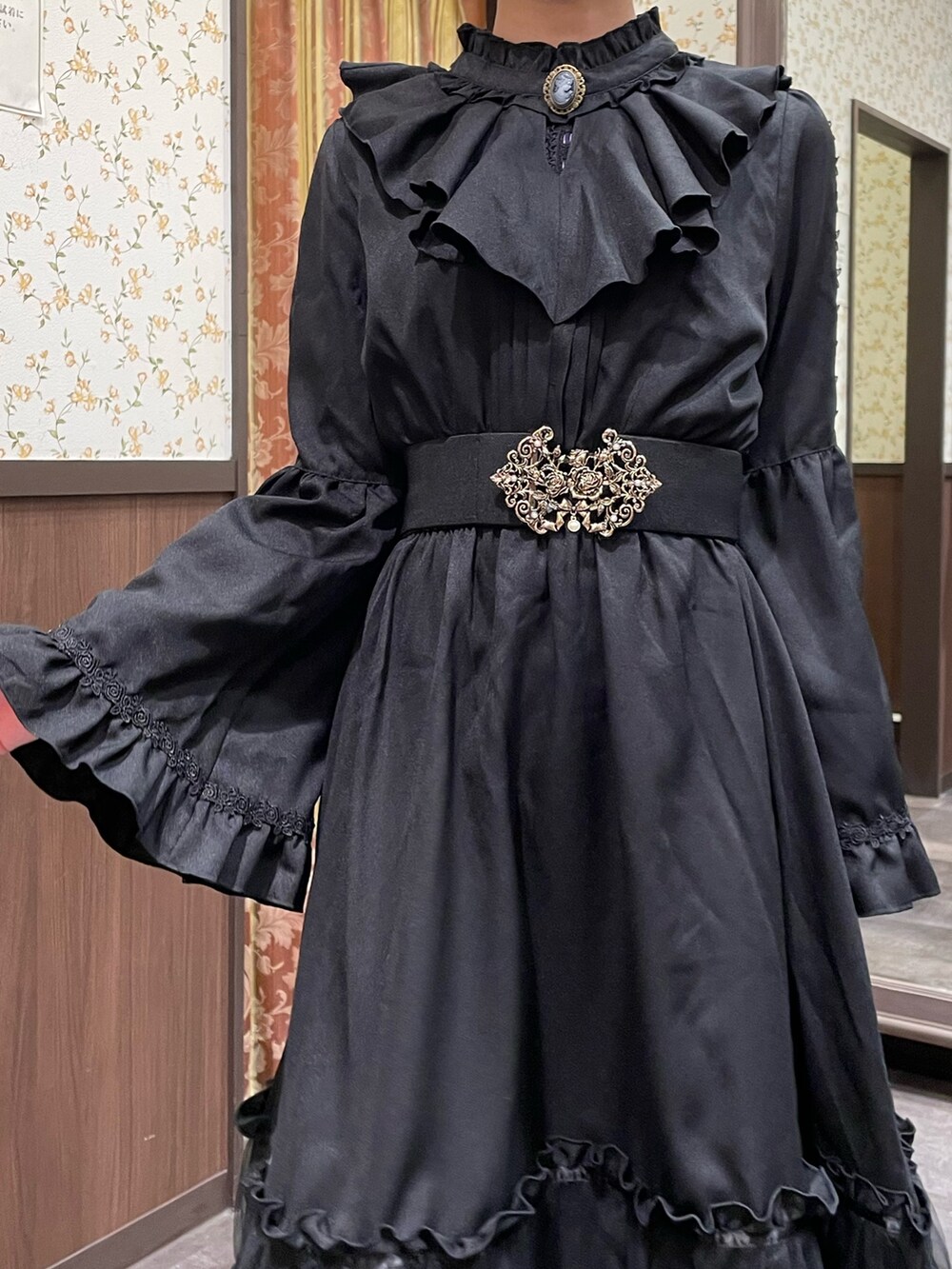 ブラック系のワンピース、ブラック系のブーツ、レッド系のショルダーバッグを着用したレディースの冬コーディネートの4枚目の写真