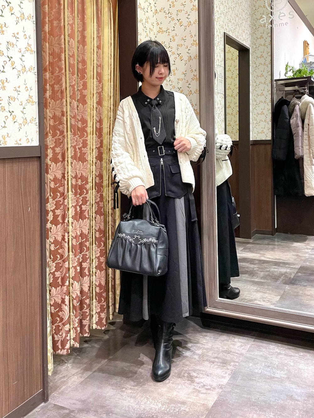 ブラック系のシャツ/ブラウス、ブラック系のブーツ、ブラック系のスカートを着用したレディースの冬コーディネートの5枚目の写真