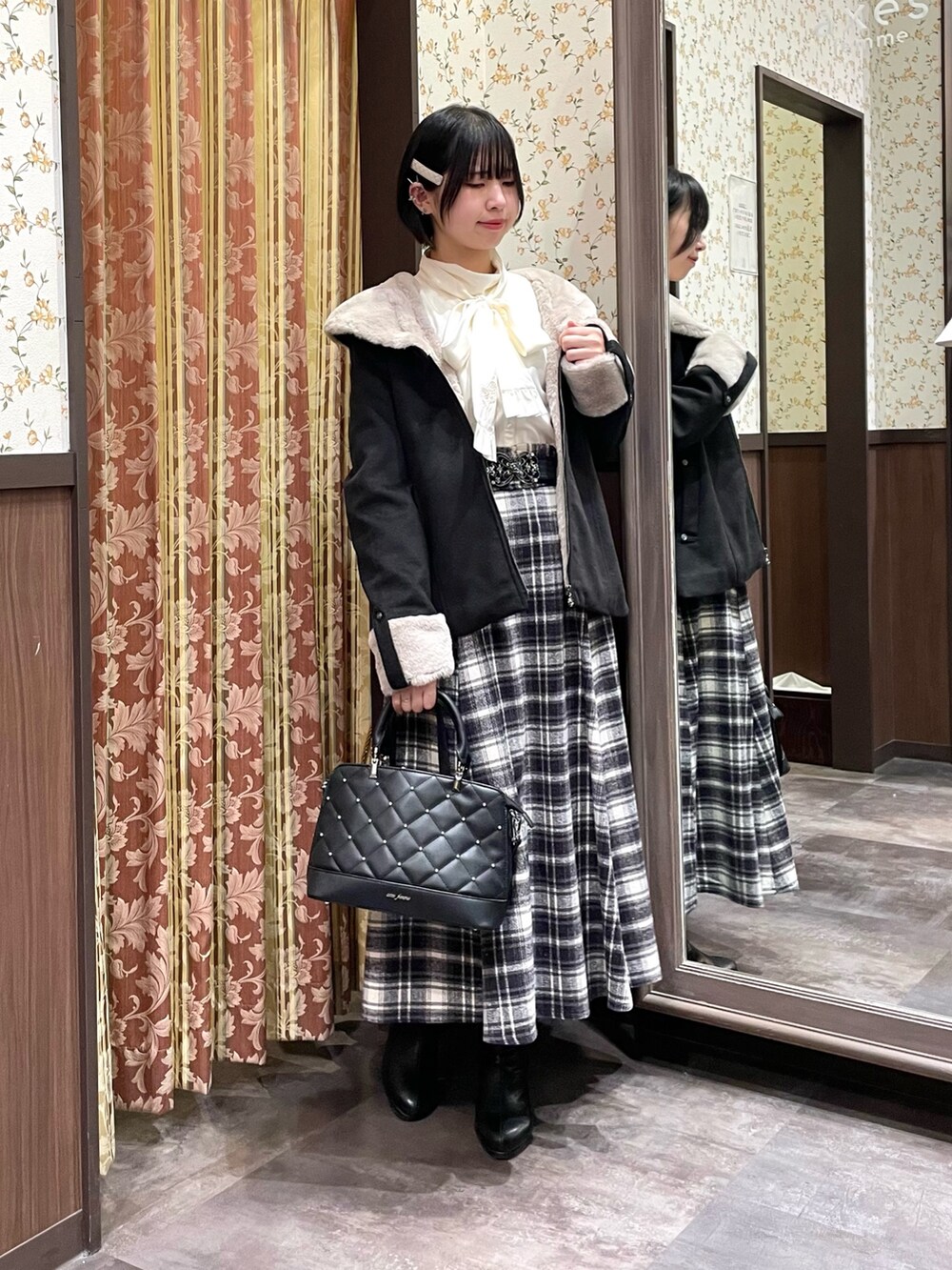 パープル系のスカート、ホワイト系のシャツ/ブラウス、ブラック系のブーツを着用したレディースの冬コーディネートの6枚目の写真