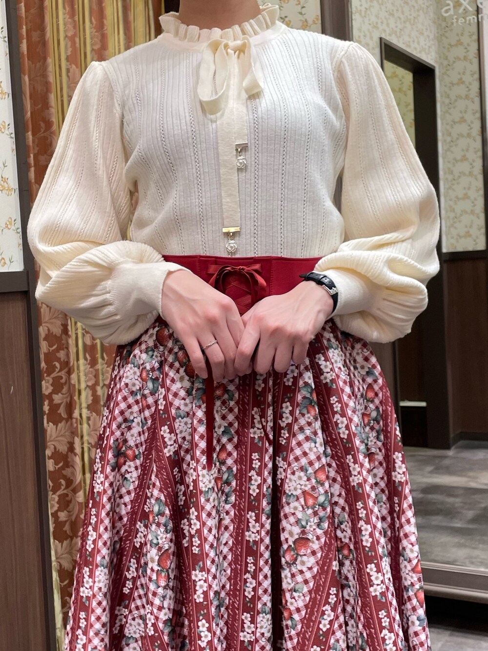 レッド系のスカート、ホワイト系のニット/セーター、ブラウン系のダッフルコートを着用したレディースの冬コーディネートの4枚目の写真