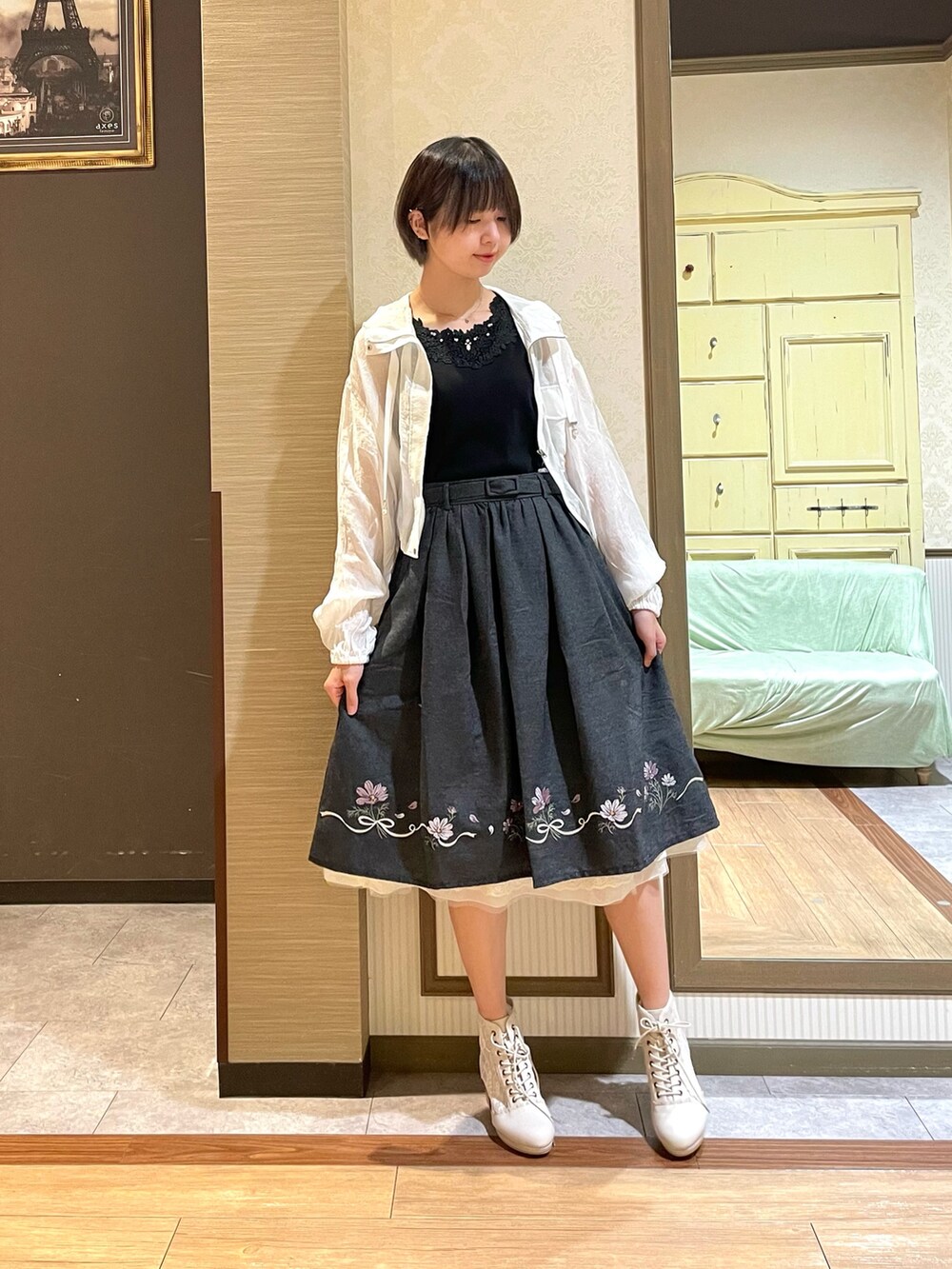 ホワイト系のブルゾン、ブラック系のタンクトップ、ブラック系のスカートを着用したレディースの秋コーディネートの3枚目の写真