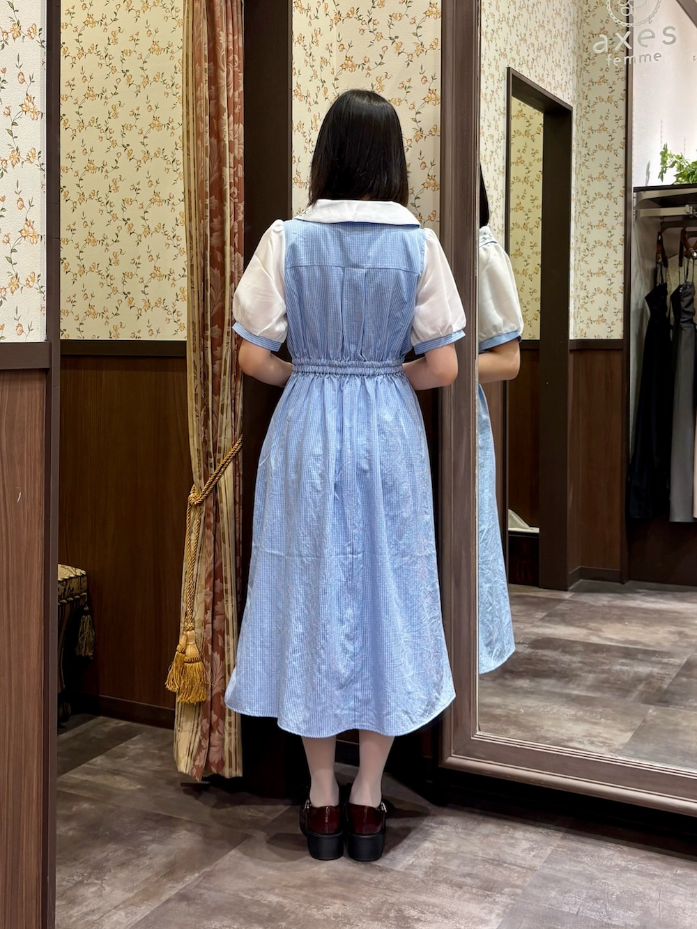 ホワイト系のタンクトップ、ブルー系のワンピース、ブラウン系のボストンバッグを着用したレディースの夏コーディネートの7枚目の写真