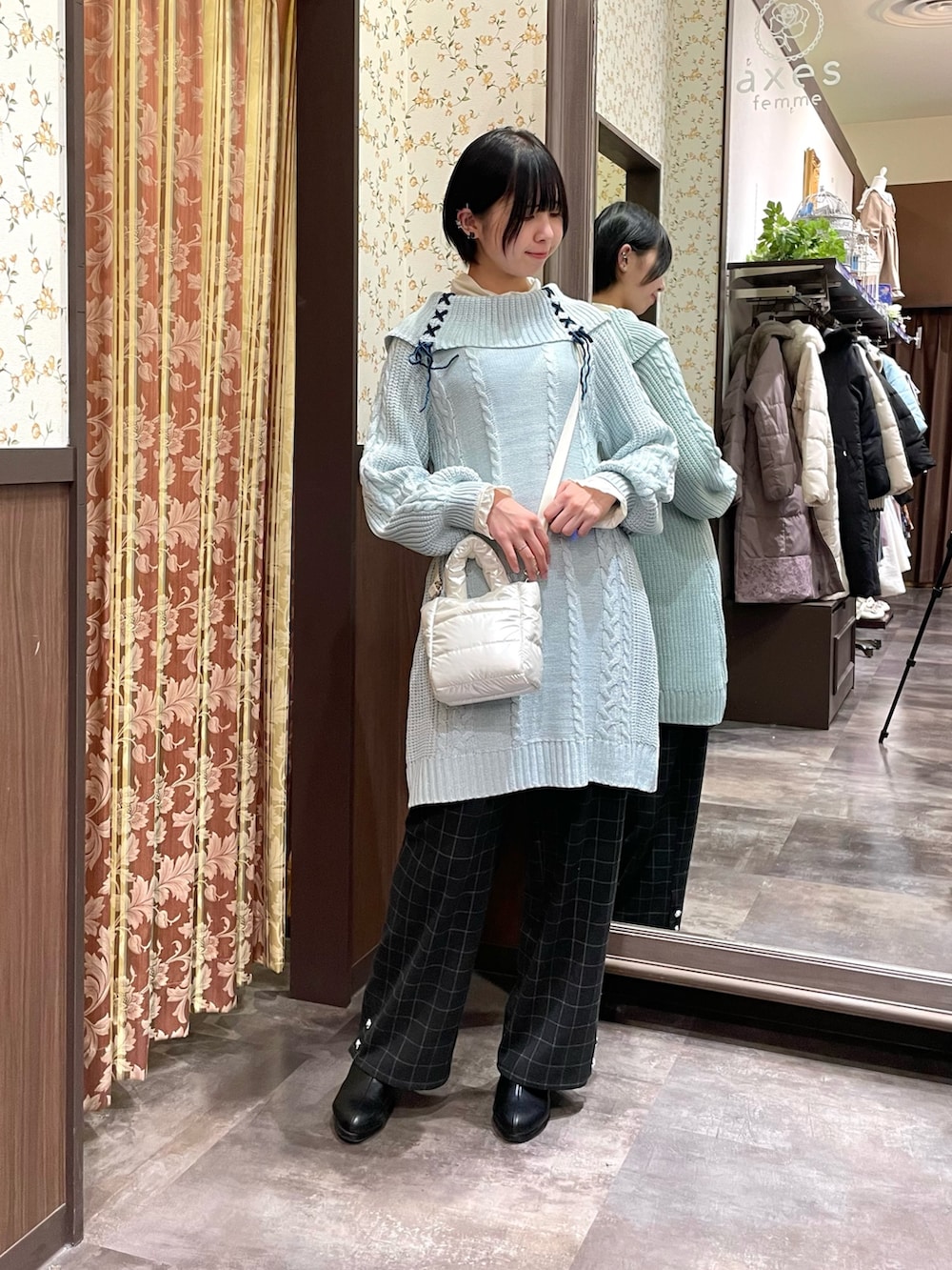 ベージュ系のダウンジャケット/コート、グリーン系のチュニック、ブラック系のその他パンツを着用したレディースの冬コーディネートの5枚目の写真