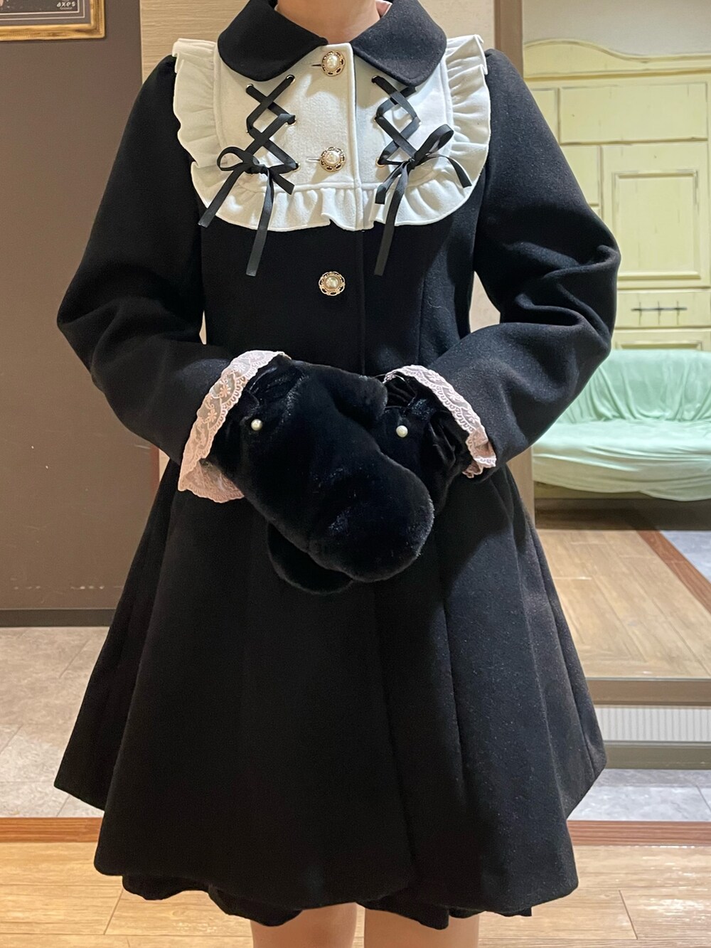 ピンク系のシャツ/ブラウス、ブラック系のワンピース、ブラック系のステンカラーコートを着用したレディースの秋コーディネートの3枚目の写真