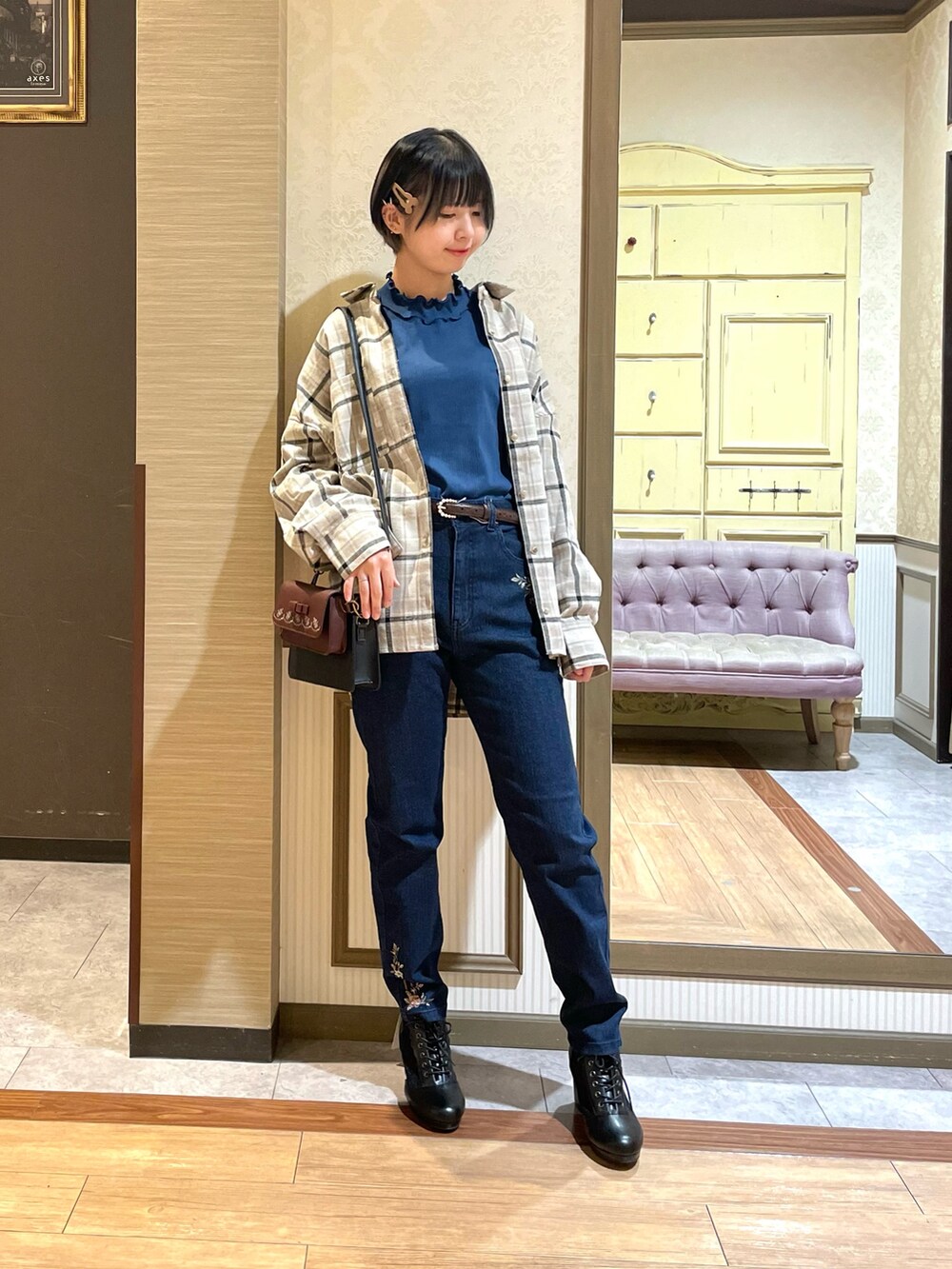 ブルー系のデニムパンツ、ブラック系のブーツ、ブルー系のTシャツ/カットソーを着用したレディースの秋コーディネートの3枚目の写真