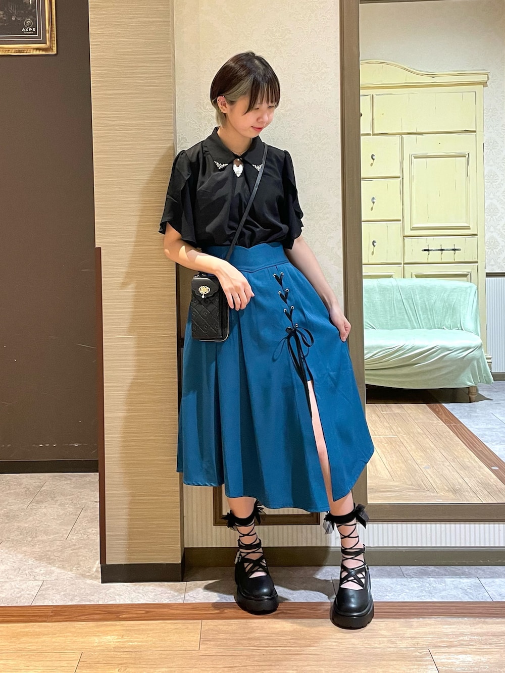 ブラック系のシャツ/ブラウス、ブラック系のパンプス、ブルー系のスカートを着用したレディースの夏コーディネートの2枚目の写真