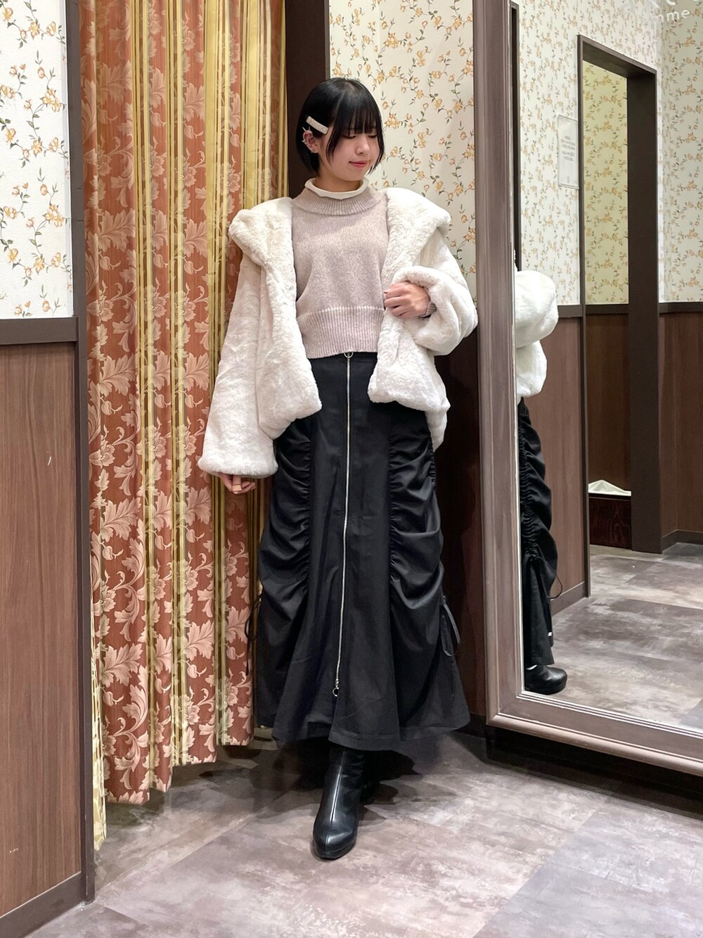 ピンク系のニット/セーター、ブラック系のスカート、ホワイト系のダッフルコートを着用したレディースの冬コーディネートの6枚目の写真