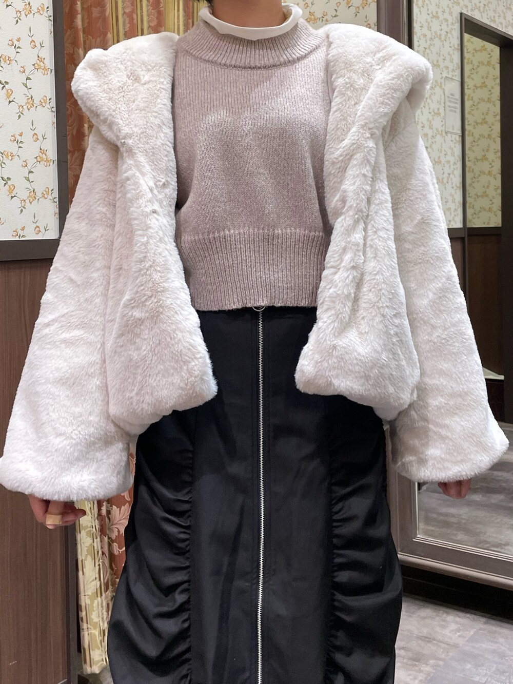 ピンク系のニット/セーター、ブラック系のスカート、ホワイト系のダッフルコートを着用したレディースの冬コーディネートの8枚目の写真