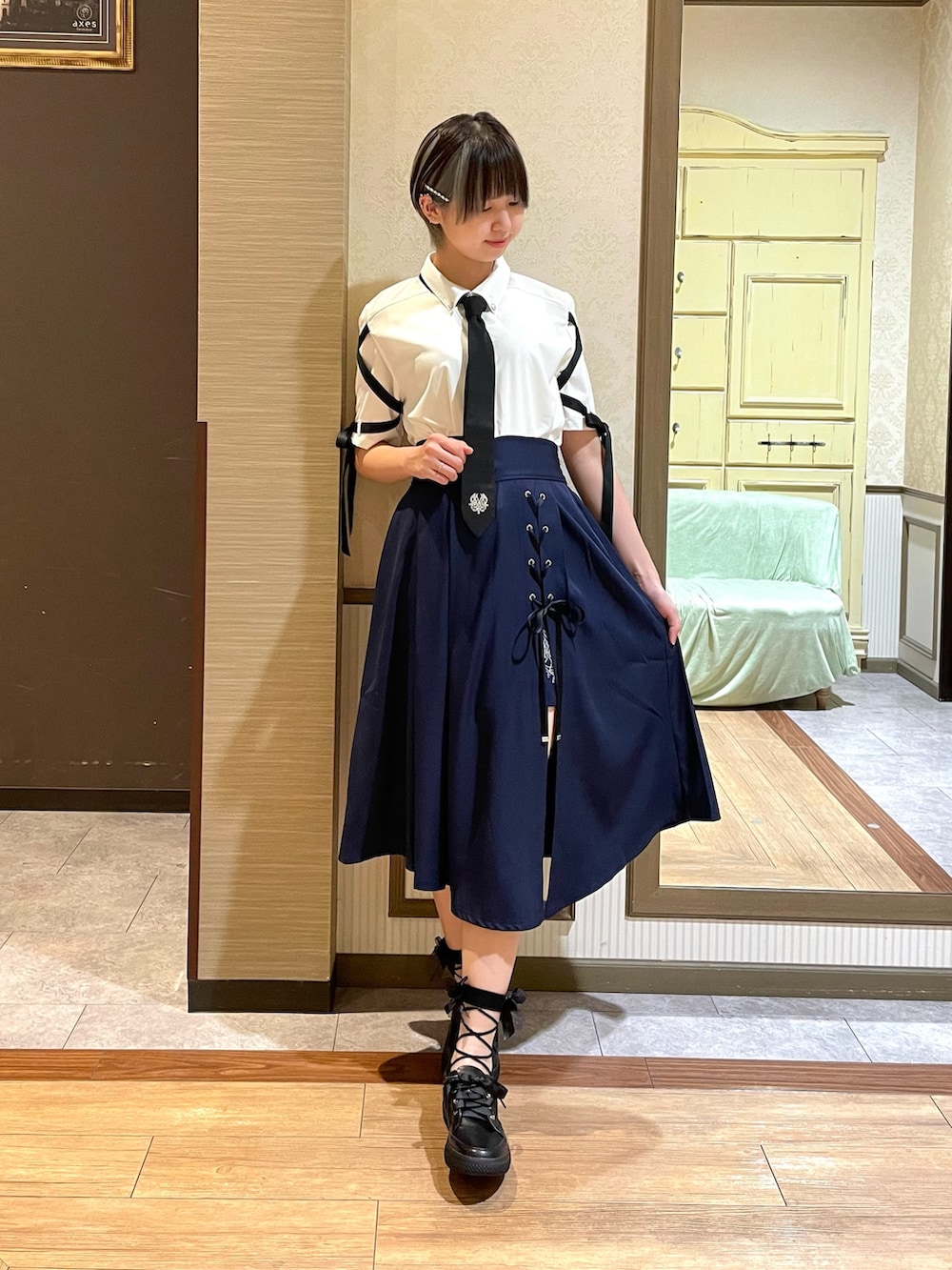 ブラック系のスニーカー、ホワイト系のタンクトップ、ホワイト系のシャツ/ブラウスを着用したレディースの夏コーディネートの2枚目の写真