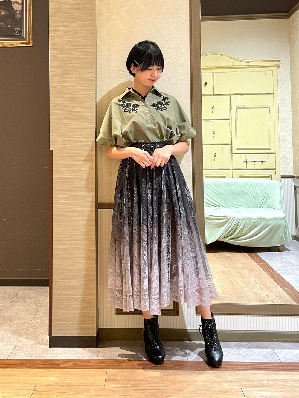 ブラック系のタンクトップ、グリーン系のシャツ/ブラウス、ブラック系のショルダーバッグを着用したレディースの秋コーディネートの2枚目の写真