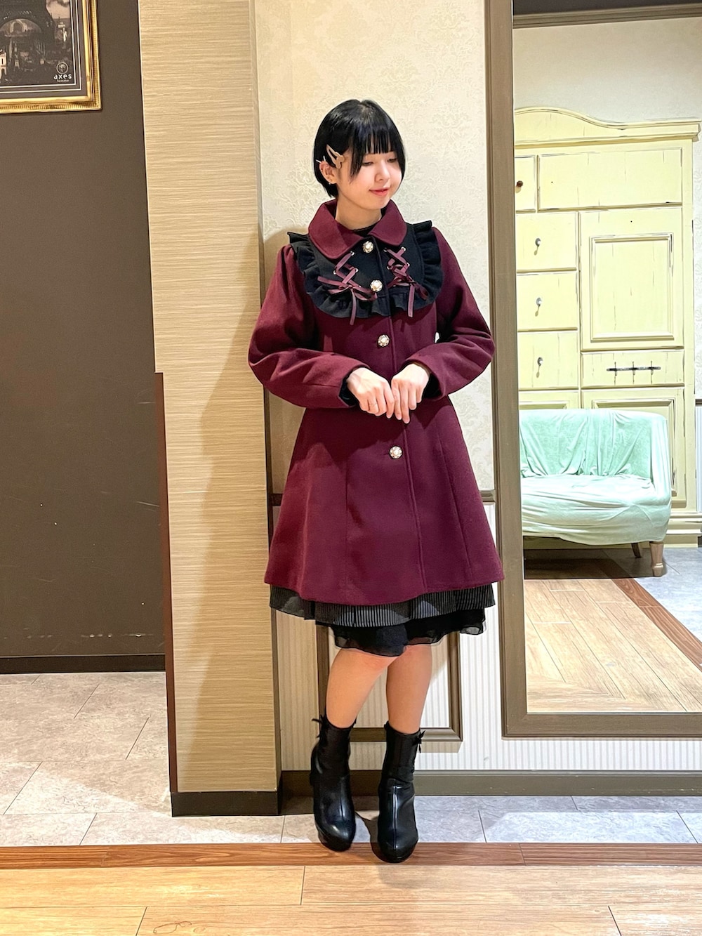 レッド系のステンカラーコート、ブラック系のシャツ/ブラウス、ブラック系のブーツを着用したレディースの秋コーディネートの4枚目の写真