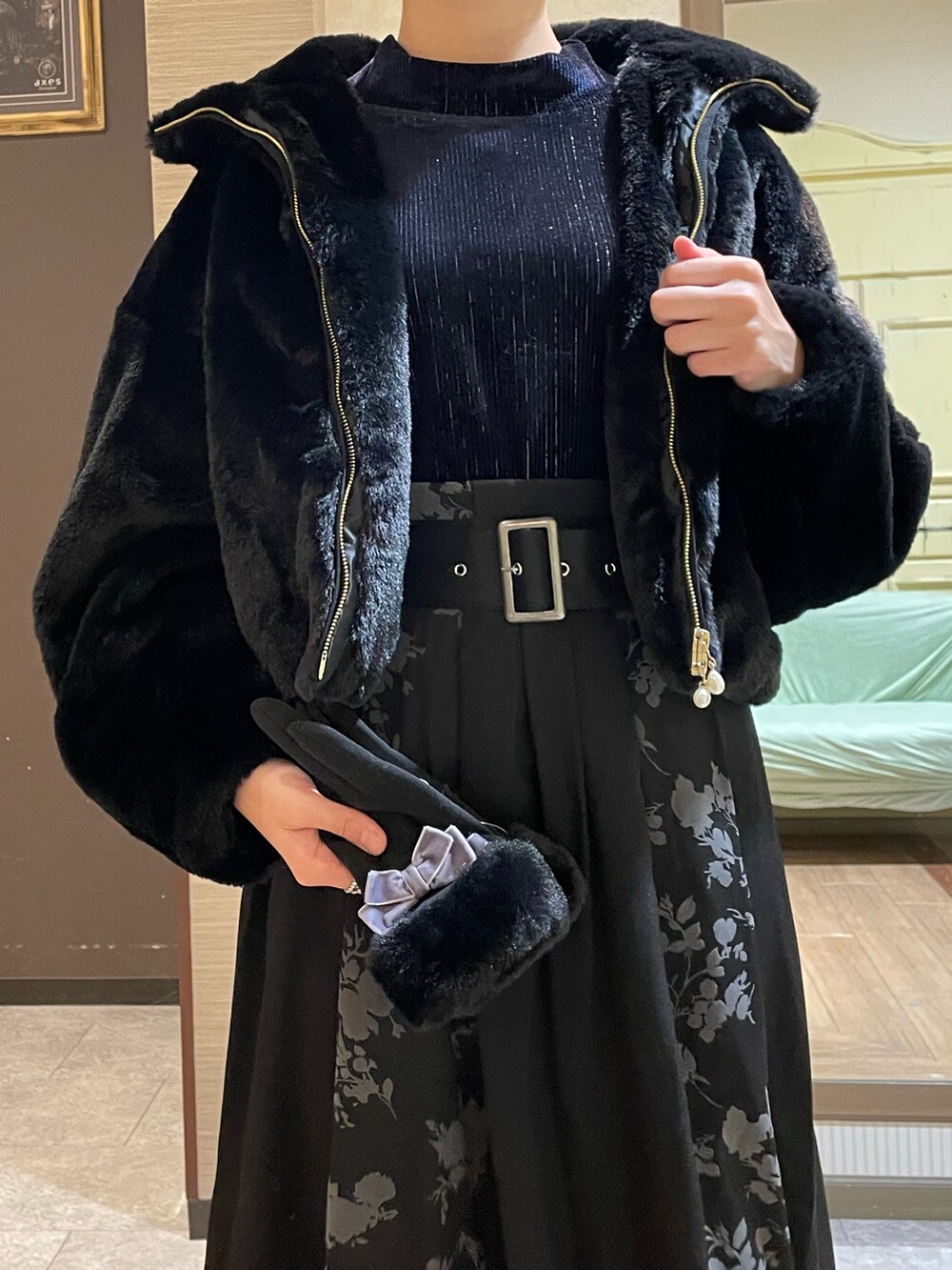 ブラック系のスカート、ブラック系のブーツ、ブラック系のタンクトップを着用したレディースの秋コーディネートの3枚目の写真