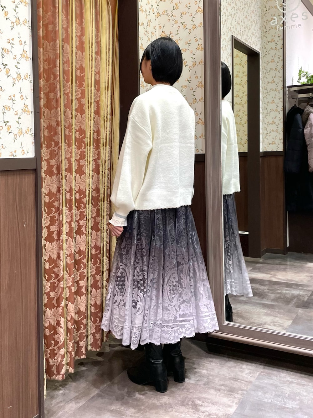 ホワイト系のニット/セーター、ホワイト系のボストンバッグ、ブラウン系のスカートを着用したレディースの冬コーディネートの5枚目の写真