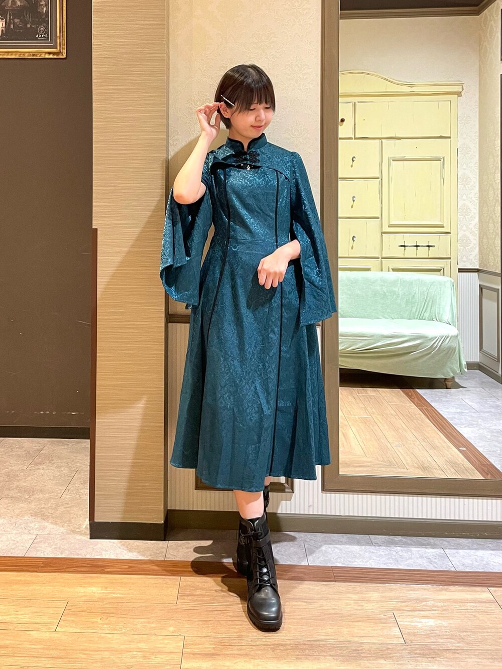 ブラック系のタンクトップ、グリーン系のワンピース、ブラック系のショルダーバッグを着用したレディースの秋コーディネートの4枚目の写真