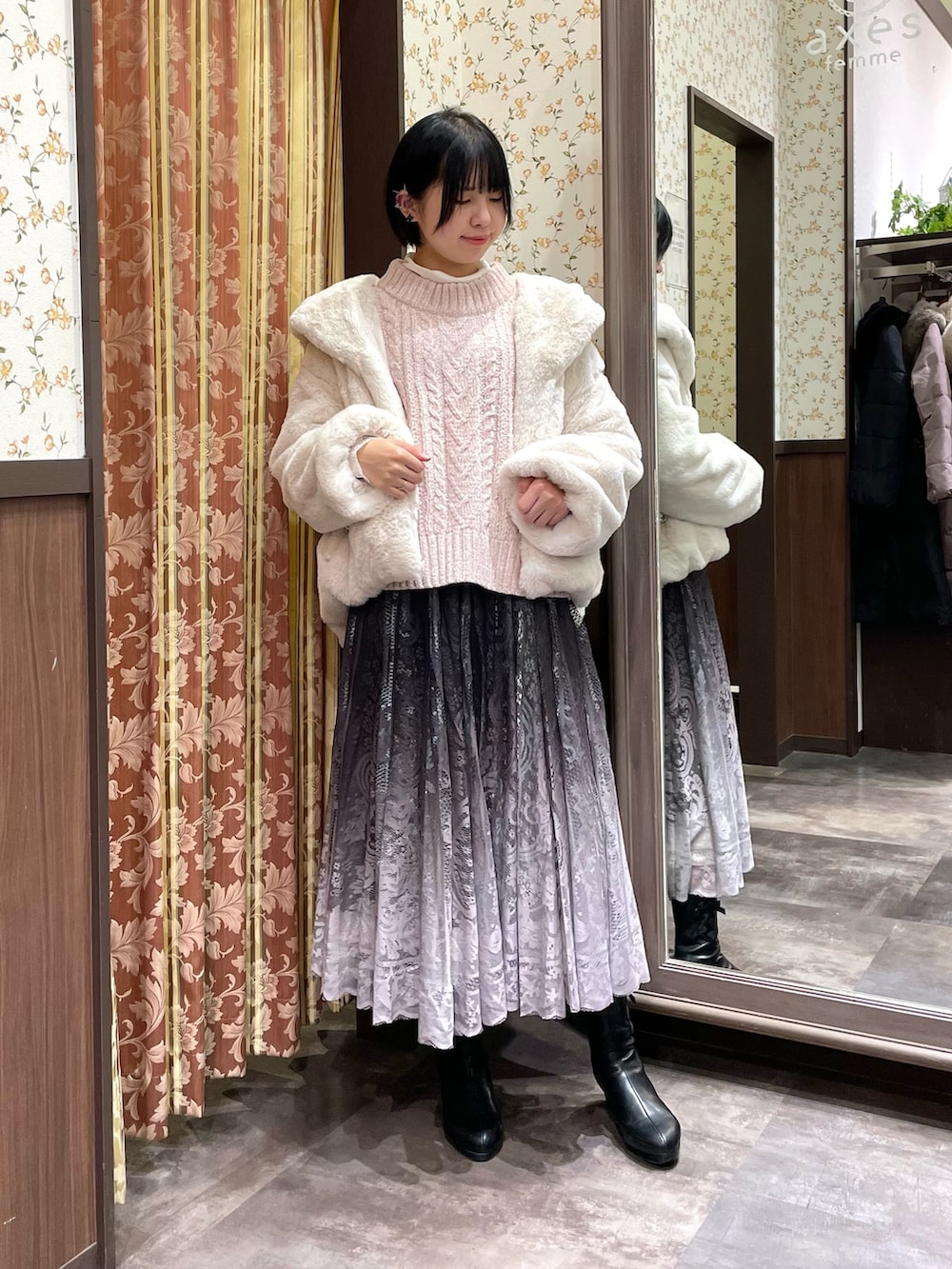 ホワイト系のダッフルコート、ピンク系のニット/セーター、ブラウン系のスカートを着用したレディースの冬コーディネートの2枚目の写真