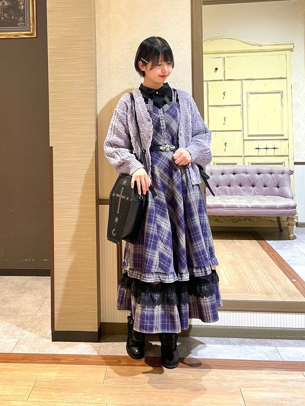 パープル系のジャンパースカート、ブラック系のシャツ/ブラウス、パープル系のカーディガン/ボレロを着用したレディースの秋コーディネートの2枚目の写真