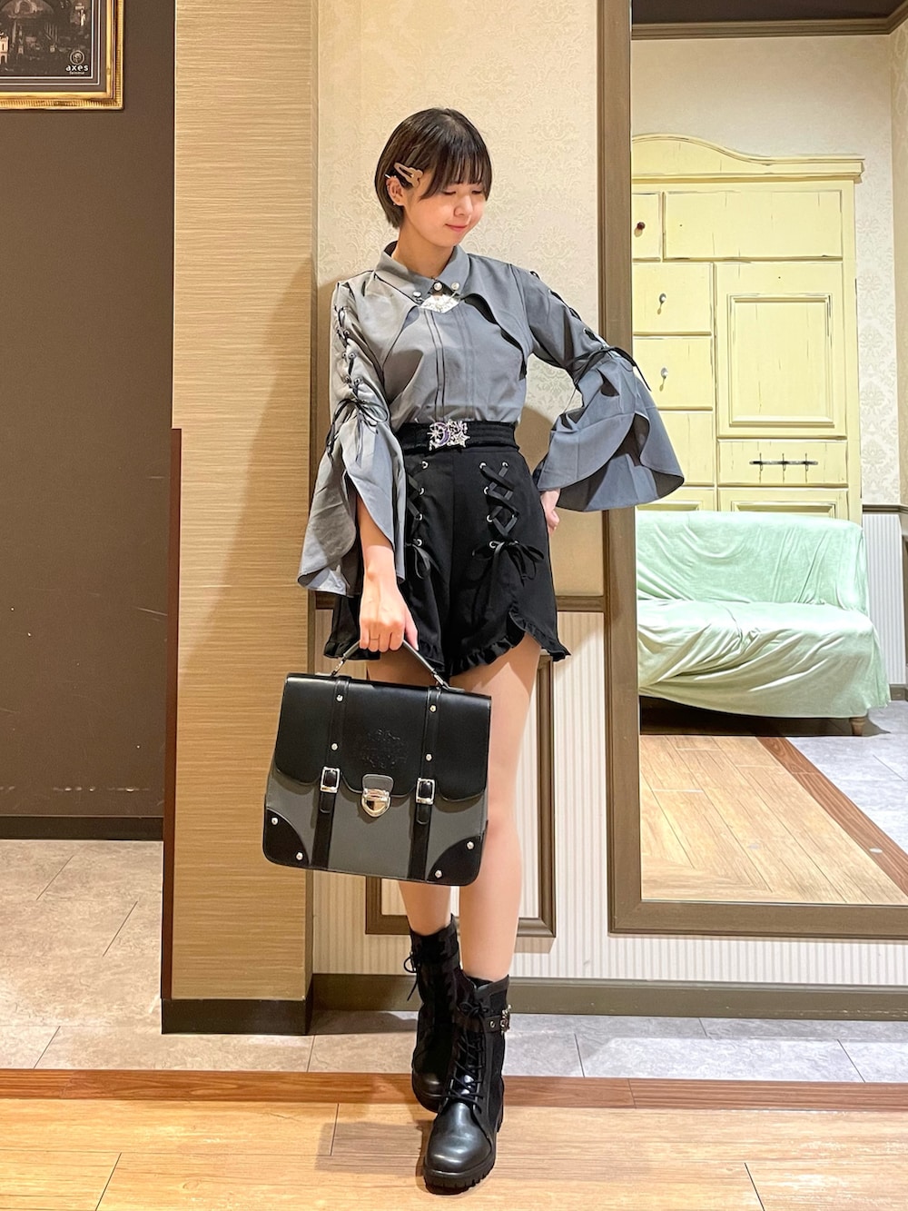 ブラック系のブーツ、グレー系のショルダーバッグ、ホワイト系のタンクトップを着用したレディースの秋コーディネートの2枚目の写真