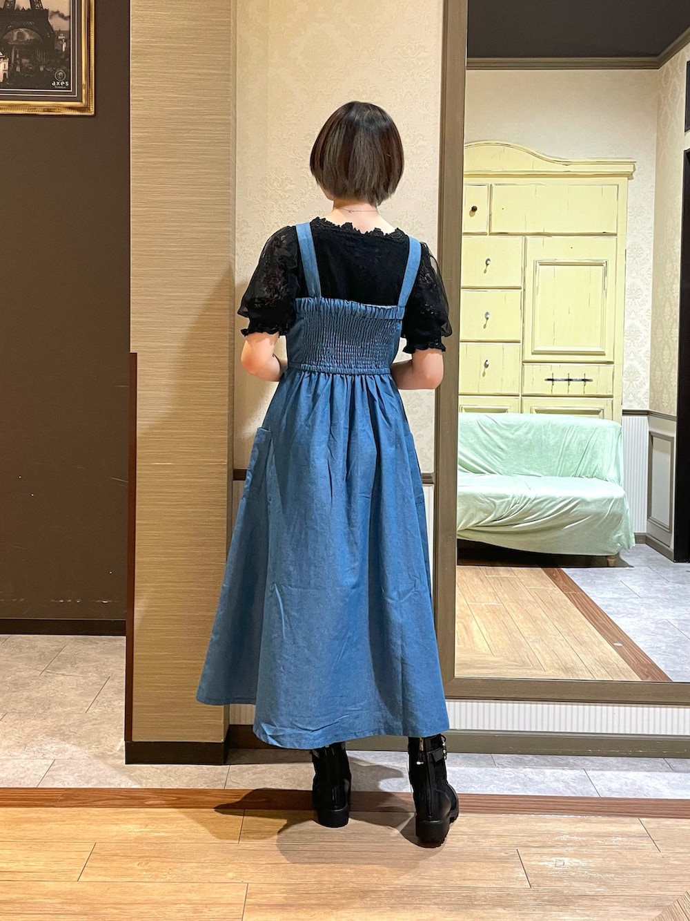 ブルー系のジャンパースカート、ブラック系のブーツを着用したレディースの秋コーディネートの2枚目の写真