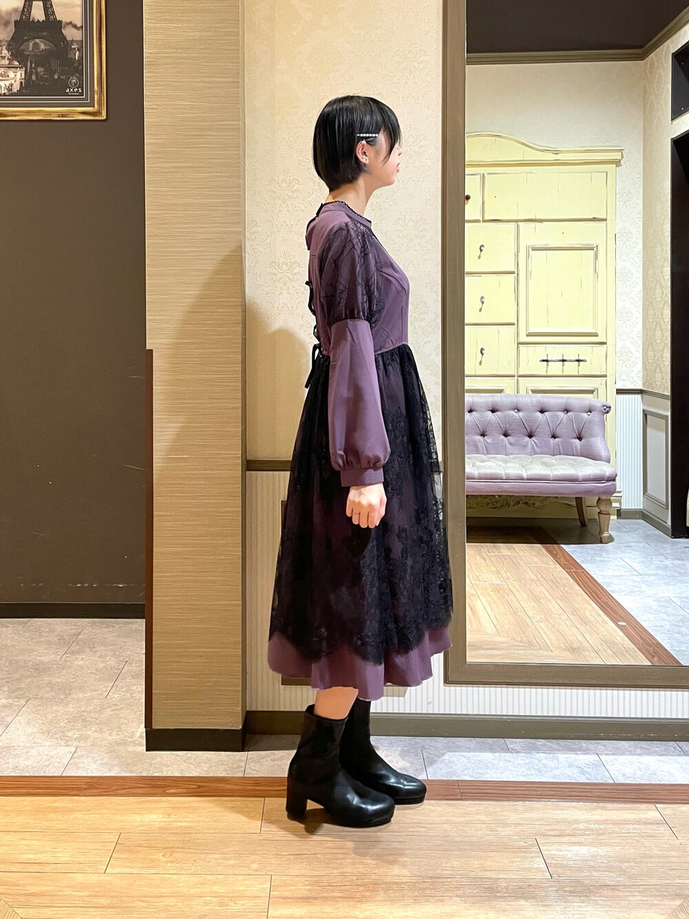 ブラック系のテーラードジャケット、パープル系のワンピース、ブラック系のブーツを着用したレディースの秋コーディネートの5枚目の写真