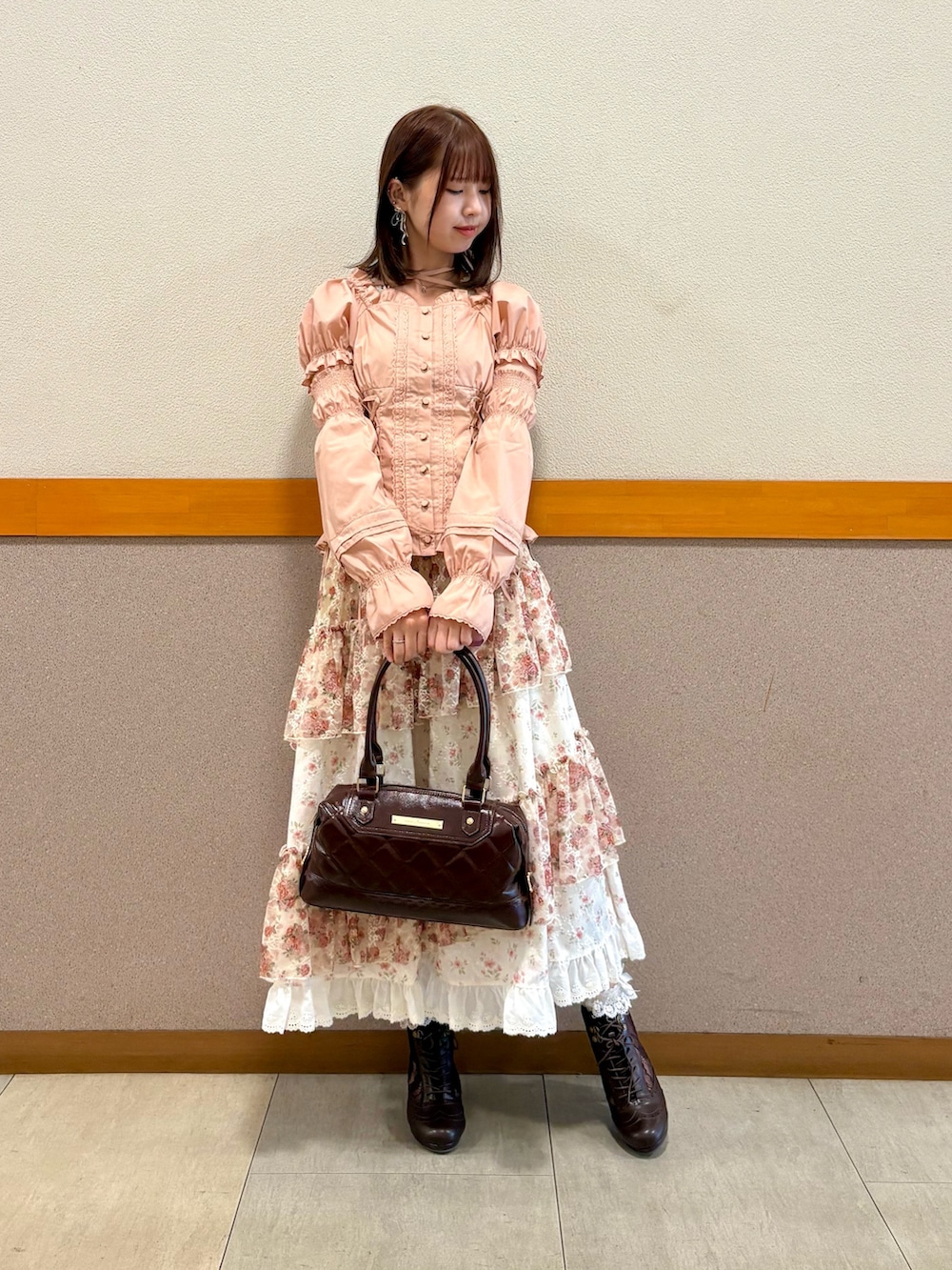 ピンク系のシャツ/ブラウス、ブラウン系のボストンバッグ、ベージュ系のスカートを着用したレディースの秋コーディネートの3枚目の写真