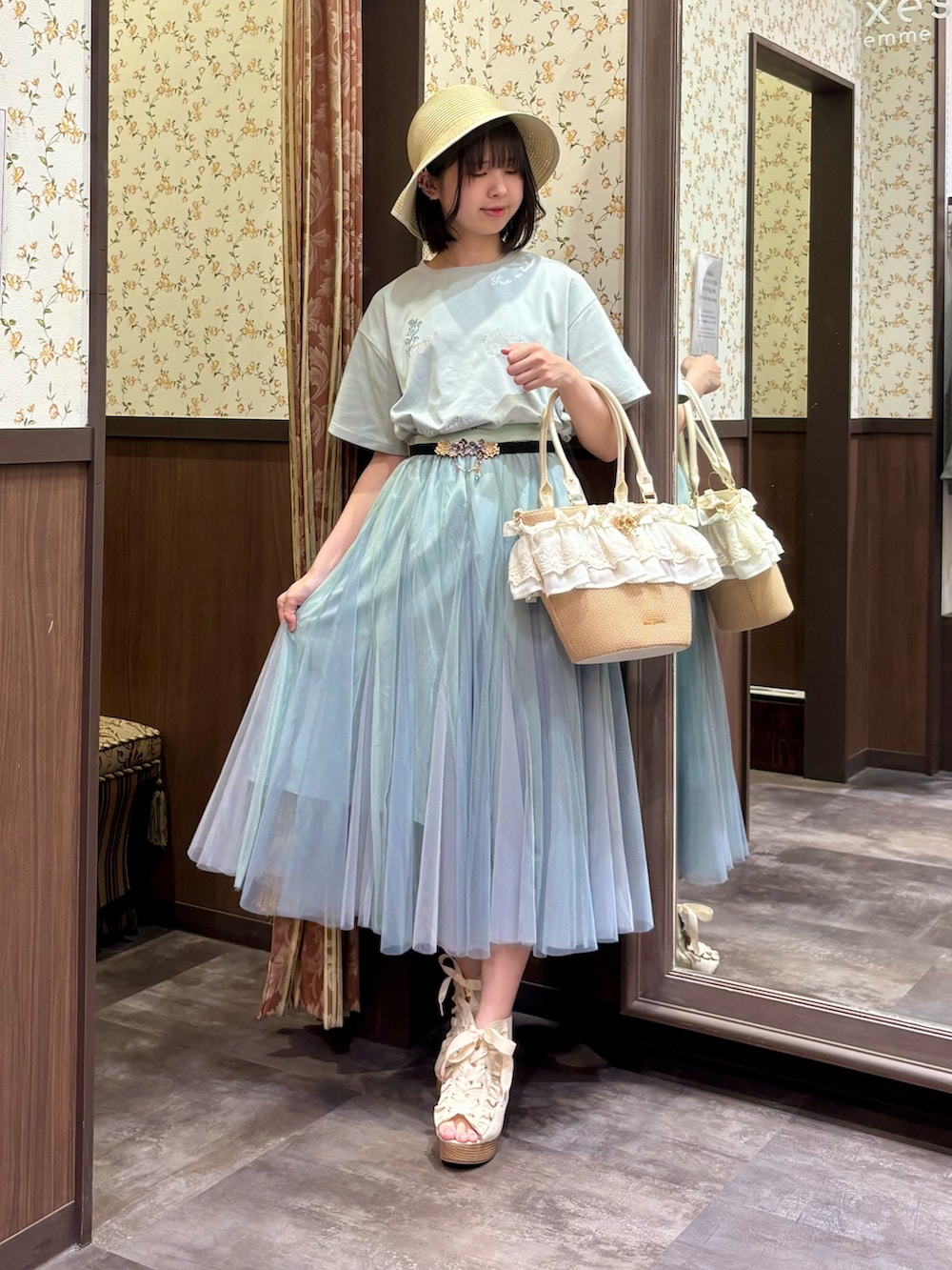 グリーン系のTシャツ/カットソー、グリーン系のスカート、ブルー系のタンクトップを着用したレディースの春コーディネートの2枚目の写真